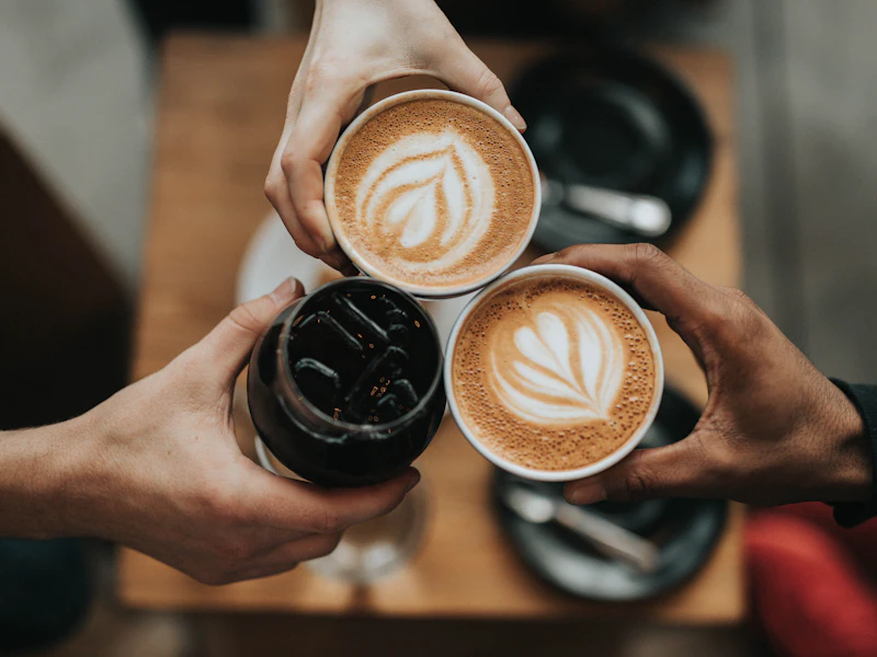 Taza de café con granos, ilustrando la guía de precios de desayunos sorpresa en Bogotá