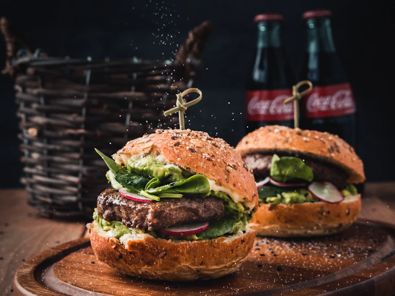 Tabla de madera con sándwich artesanal doble proteína y bebidas para desayuno sorpresa de hombre en Bogotá